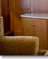 Curved media storage and matching settee and table pedestal in oak, which J.T. John designed for the same Washington based yacht.