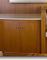 Curved media storage and matching settee and table pedestal in oak, which J.T. John designed for the same Washington based yacht.